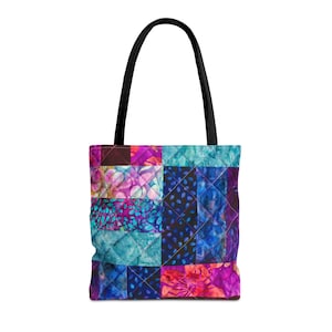 May include: A quilted tote bag with a patchwork design in shades of blue, purple, and pink. The bag features a black handle and a diamond-stitched pattern. The bag is designed for carrying items.