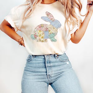 Puede incluir: Camiseta color crema con un dise&ntilde;o de conejo de patchwork. El conejo est&aacute; compuesto por telas florales, de cuadros y de encaje en colores pastel. La camiseta se combina con vaqueros azules de lavado claro.