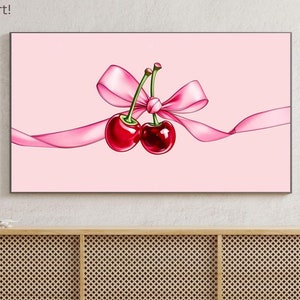 Könnte beinhalten: Zwei rote Kirschen, die mit einem rosa Band auf einem rosa Hintergrund zusammengebunden sind. Die Kirschen befinden sich auf einem Fernsehbildschirm mit dem Text "Dreamy Pixel Art! TV Frame Art!" über dem Bildschirm.