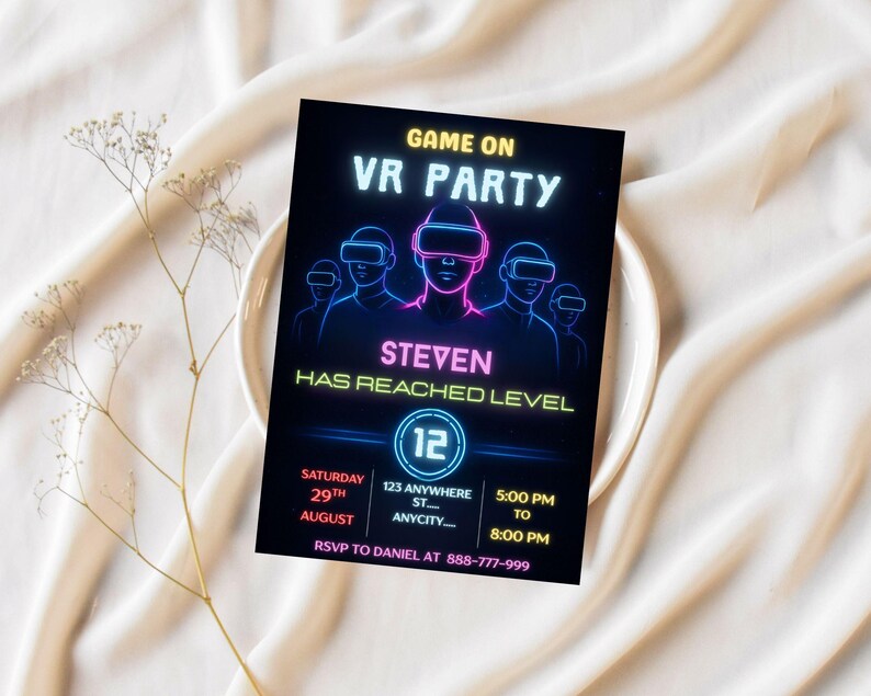 Puede incluir: Tarjeta de invitaci&oacute;n negra con texto y gr&aacute;ficos de ne&oacute;n para una fiesta de realidad virtual. La tarjeta presenta el texto "GAME ON VR PARTY" y "STEVEN HAS REACHED LEVEL". Detalles de fecha, hora e informaci&oacute;n de confirmaci&oacute;n de asistencia. La tarjeta est&aacute; sobre un plato blanco.