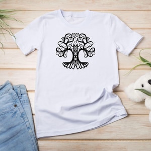 May include: White t-shirt with a black tree of life design. The tree has intricate branches and swirls.