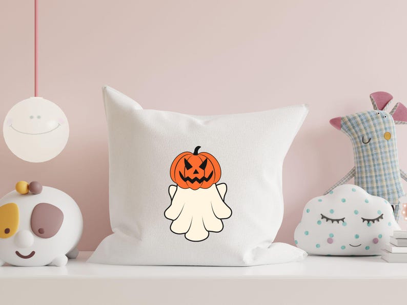 Pu&ograve; includere: Un cuscino bianco con un fantasma che indossa una zucca intagliata come testa. Il fantasma &egrave; bianco e la zucca &egrave; arancione con un viso nero.