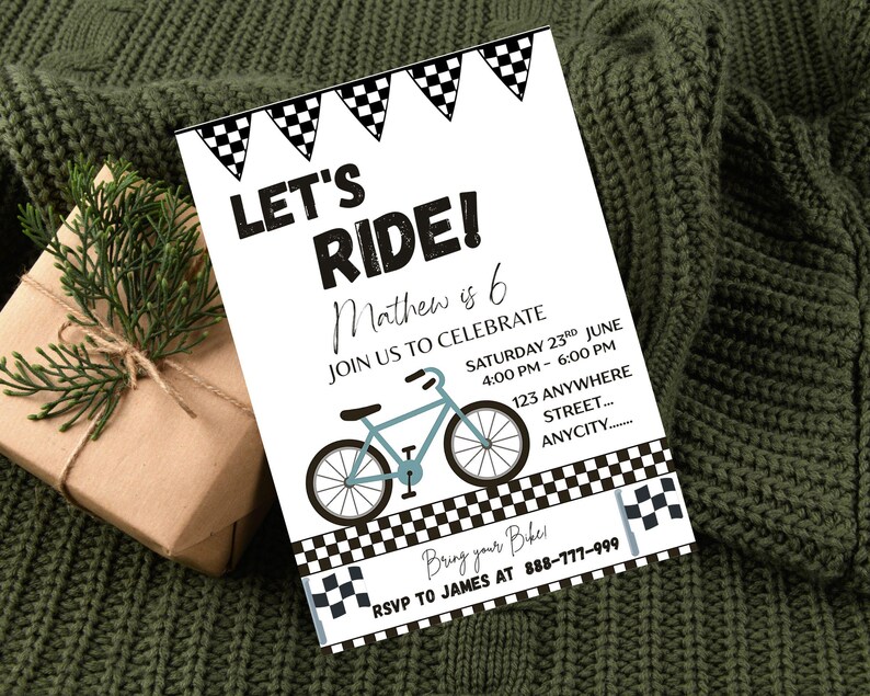 May include: White invitation card with the text "LET'S RIDE!" and a light blue bicycle illustration. The card includes event details and a checkered flag design. A wrapped gift and greenery are in the background.