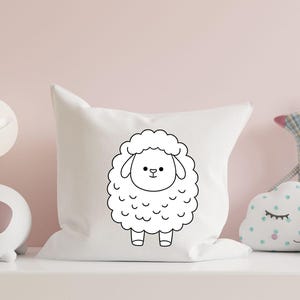 May include: A white pillow with a black outline of a cartoon sheep on it. The sheep has a simple face with two eyes, a nose, and a mouth.