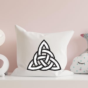 May include: A white pillow with a black Celtic knot design. The knot is a traditional symbol of love, friendship, and unity.