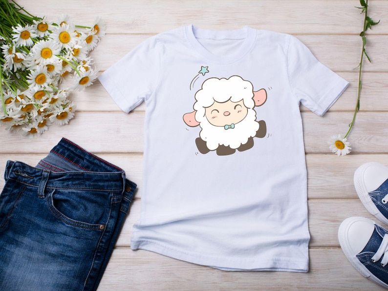 May include: White t-shirt with a cartoon illustration of a white lamb with a blue bow tie. The lamb is smiling and has a star above its head.