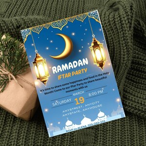 Op de afbeelding: Een blauwe en gouden Ramadan Iftar Party-uitnodiging met een halve maan en lantaarns. De uitnodiging bevat de datum, tijd en locatie van het evenement. RSVP naar Alena 555-222-333.