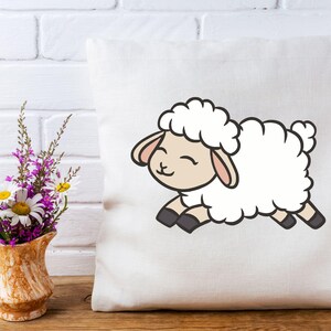 May include: White pillow with a cartoon illustration of a white sheep with black hooves and a pink nose. The sheep is smiling and has its tongue sticking out.