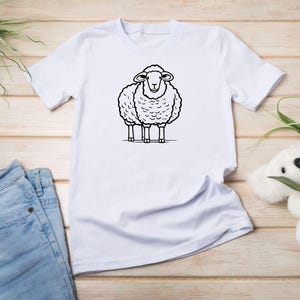 May include: White t-shirt with a black and white cartoon sheep illustration.