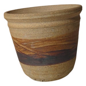 May include: A brown ceramic planter with a wide rim and a striped design in shades of brown, black, and white.