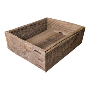 May include: A rectangular wooden box with a rustic, weathered appearance. The box is constructed from reclaimed wood, showcasing natural grain patterns and variations in color. The open top reveals the interior.
