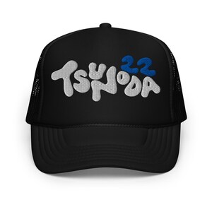 Pode incluir: Boné de caminhoneiro preto com a palavra "TSUNODA" bordada em branco e o número "22" em azul. O boné tem uma parte traseira em malha e uma aba curva.