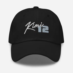 May include: Black baseball cap with white embroidered text that says "Kimi 12".