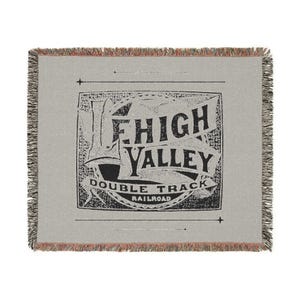May include: A woven throw blanket with a vintage-style logo for the Lehigh Valley Double Track Railroad. The logo is in black and white on a gray background.