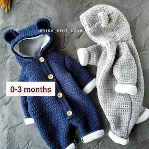 May include: Two crocheted baby onesies with bear ears and hoods. One is blue and the other is gray. Both have white fur trim. The onesies are labeled "0-3 months".