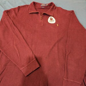 Può includere: Un maglione a maniche lunghe color granata con una chiusura a zip a quarto. Il maglione presenta un piccolo logo ricamato sul petto sinistro con il testo "POLO RALPH LAUREN".