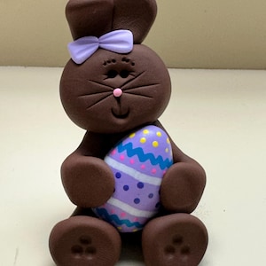 Chocolate bunny with a purple Easter egg
