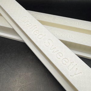 May include: Two white foam blocks with the text "Crafted Sweetly" embossed on them.