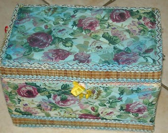 Può includere: Una scatola con motivo floreale blu e bianco con coperchio in bambù marrone chiaro e nastro giallo.