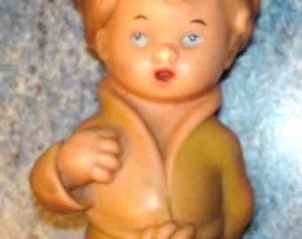 Niño raro y muy antiguo que hace ruido y lleva una bata