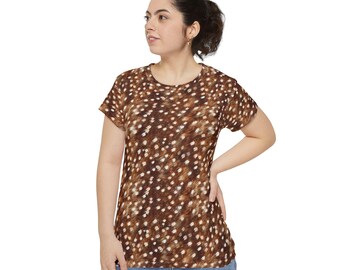 May include: A short-sleeved t-shirt featuring a brown and white spotted pattern that resembles animal fur. The garment has a round neckline and a straight hem, paired with blue denim jeans. The fabric displays a textured, multi-tonal brown print.