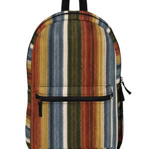 May include: A backpack featuring a vertical striped pattern in shades of rust orange, olive green, mustard yellow, and slate blue. The bag includes a front zippered pocket, a black top handle, black zipper pulls, and a black mesh side pocket.