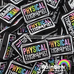 May include: A collection of black rectangular beads with the words "PHYSICAL THERAPIST" in colorful letters. The text is framed in a white border. The beads are scattered, with some partially visible.