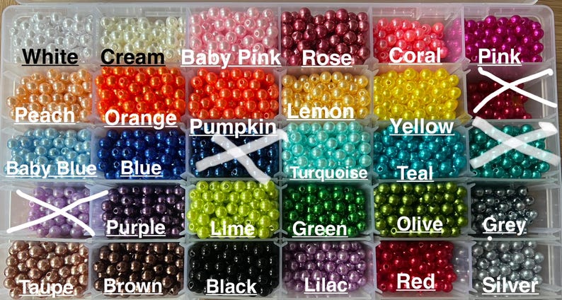 May include: A clear plastic storage container with thirty compartments filled with round, glossy beads in various colors. The colors are labeled as white, cream, baby pink, rose, coral, pink, peach, orange, pumpkin, lemon, yellow, blue, turquoise, teal, purple, lime, green, olive, grey, taupe, brown, black, lilac, red, and silver.