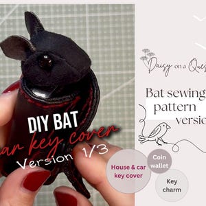 Puede incluir: Una funda para llave con forma de murciélago negro con costuras rojas, que presenta una cabeza oscura texturizada y alas que envuelven la llave. La imagen incluye el texto DIY BAT car key cover Version 1/3, Daisy on a Quest, Bat sewing pattern version 1.
