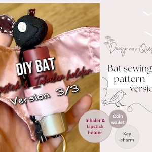 May include: A fabric bat-shaped holder in black and dusty pink, designed to carry a lipstick or inhaler. The bat features brown ribbon ears with white dots and a gold-toned metal ring at the base. Text on the image reads DIY BAT, Lipstick & Inhaler holder, Version 3/3, Daisy on a Quest, Bat sewing pattern version 3, Inhaler & Lipstick holder, Coin wallet, and Key charm.