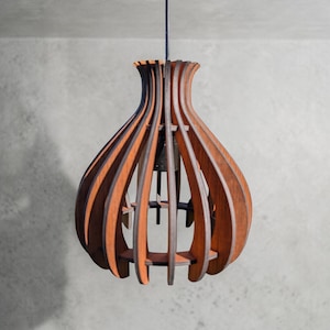 May include: A wooden pendant light fixture with a teardrop shape. The fixture is made of vertical wooden slats in a warm brown color, creating an open, airy design. The light hangs from a black cord, showcasing a modern, natural aesthetic.