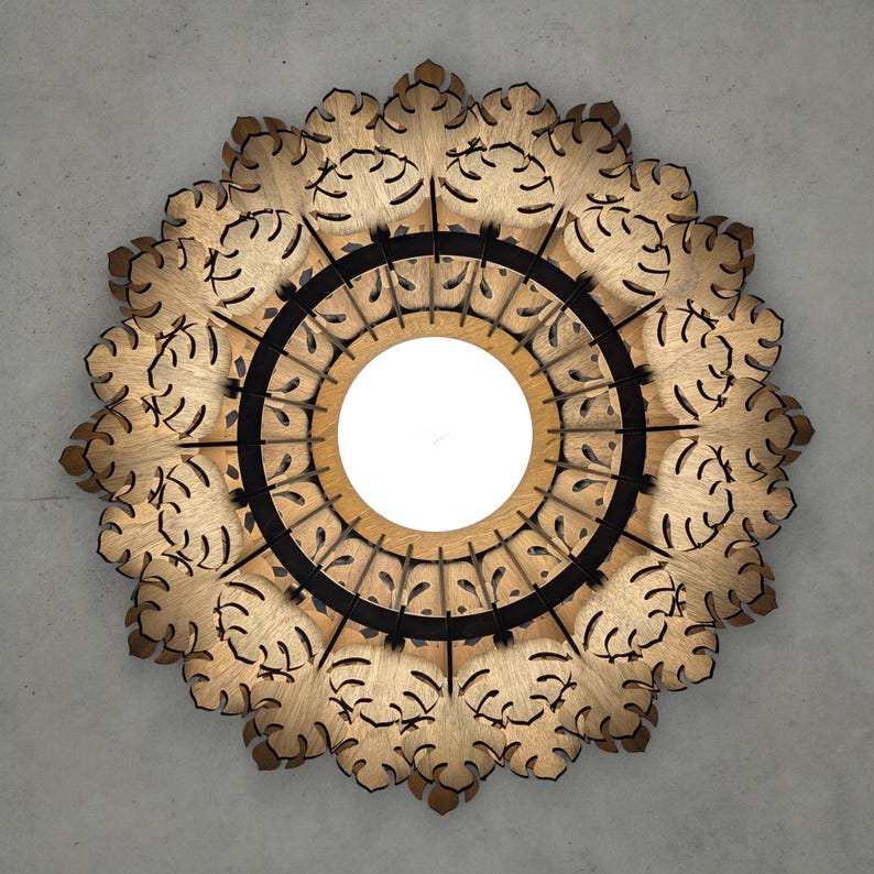 May include: A decorative wooden light fixture with a circular design. The fixture features a central white light source surrounded by a black ring and an outer ring of intricately cut wooden leaves. The overall shape is a symmetrical floral pattern.