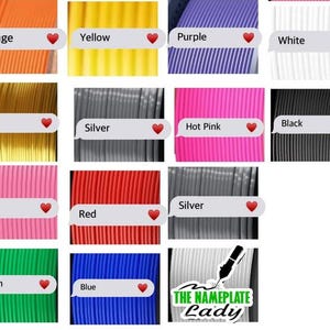 May include: A collection of spools of filament in various colors, including orange, yellow, purple, white, gold, black, silver, hot pink, pink, red, green, and blue. Each spool is labeled with its color name.