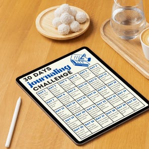 May include: A 30-day journaling challenge on a tablet with a white stylus. The challenge includes prompts for each day, such as "Write about your best day" and "What are you grateful for?"
