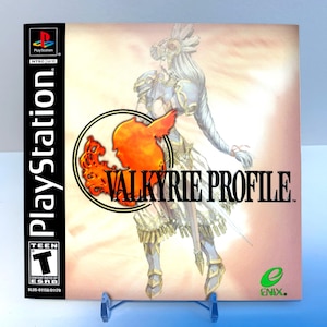 May include: PlayStation game case cover art for Valkyrie Profile. The cover features a female warrior in a white and blue outfit with a red bird logo and the game title.