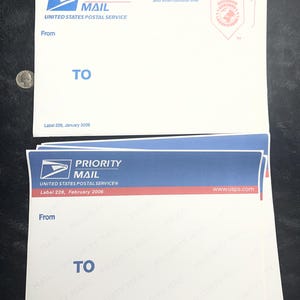 May include: Two white Priority Mail envelopes from the United States Postal Service. The envelopes have blue and red stripes at the top, with the words "PRIORITY MAIL" and "UNITED STATES POSTAL SERVICE" printed on them. The word "TO" is printed in blue.