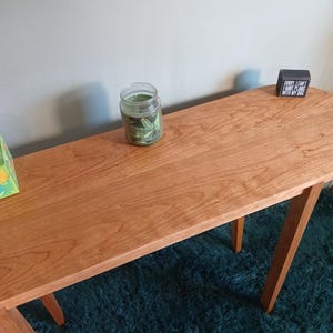 Puede incluir: Un letrero de madera r&uacute;stica con la frase "Welcome to our home" en letras blancas. El letrero presenta un acabado envejecido y un dise&ntilde;o sencillo y acogedor, perfecto para la entrada.