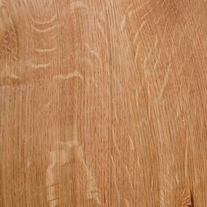 May include: Close-up of a section of light brown wood grain. The wood has a natural, textured surface with visible grain patterns and knots. The colour is a warm, natural tone.