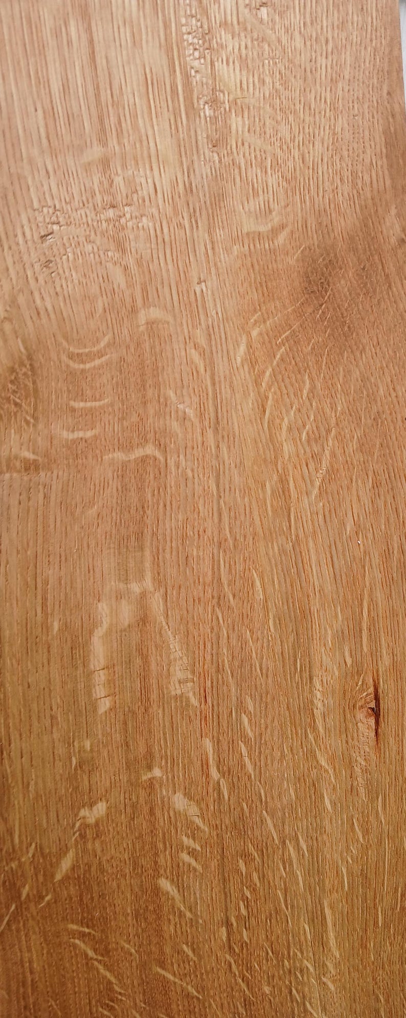 May include: Close-up of a section of light brown wood grain. The wood has a natural, textured surface with visible grain patterns and knots. The colour is a warm, natural tone.