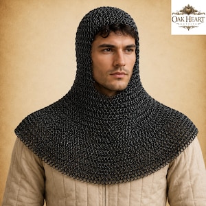 May include: Black chainmail coif with a hood, designed to protect the head and neck. The coif is made of small, interlocking metal rings. The image also includes the Oak Heart Outfits logo in the upper right corner.