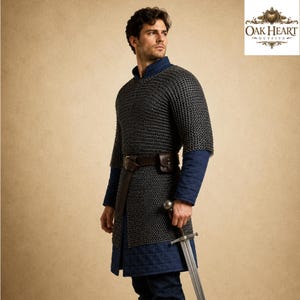 May include: A medieval-style outfit featuring a chainmail shirt, blue quilted undergarments, and a brown leather belt with a pouch. The outfit includes a long sword. The Oak Heart Outfits logo is in the upper right corner.