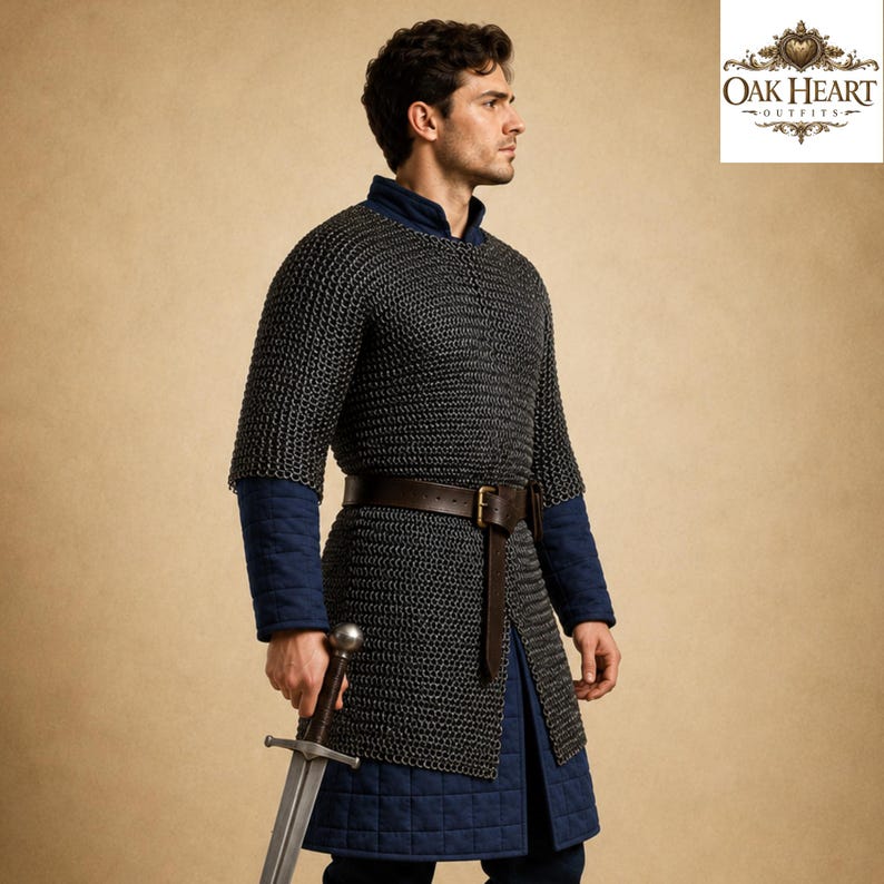 May include: A medieval chainmail shirt with a brown leather belt and a long sword. The shirt is worn over a blue padded undergarment. The image is set against a neutral background.