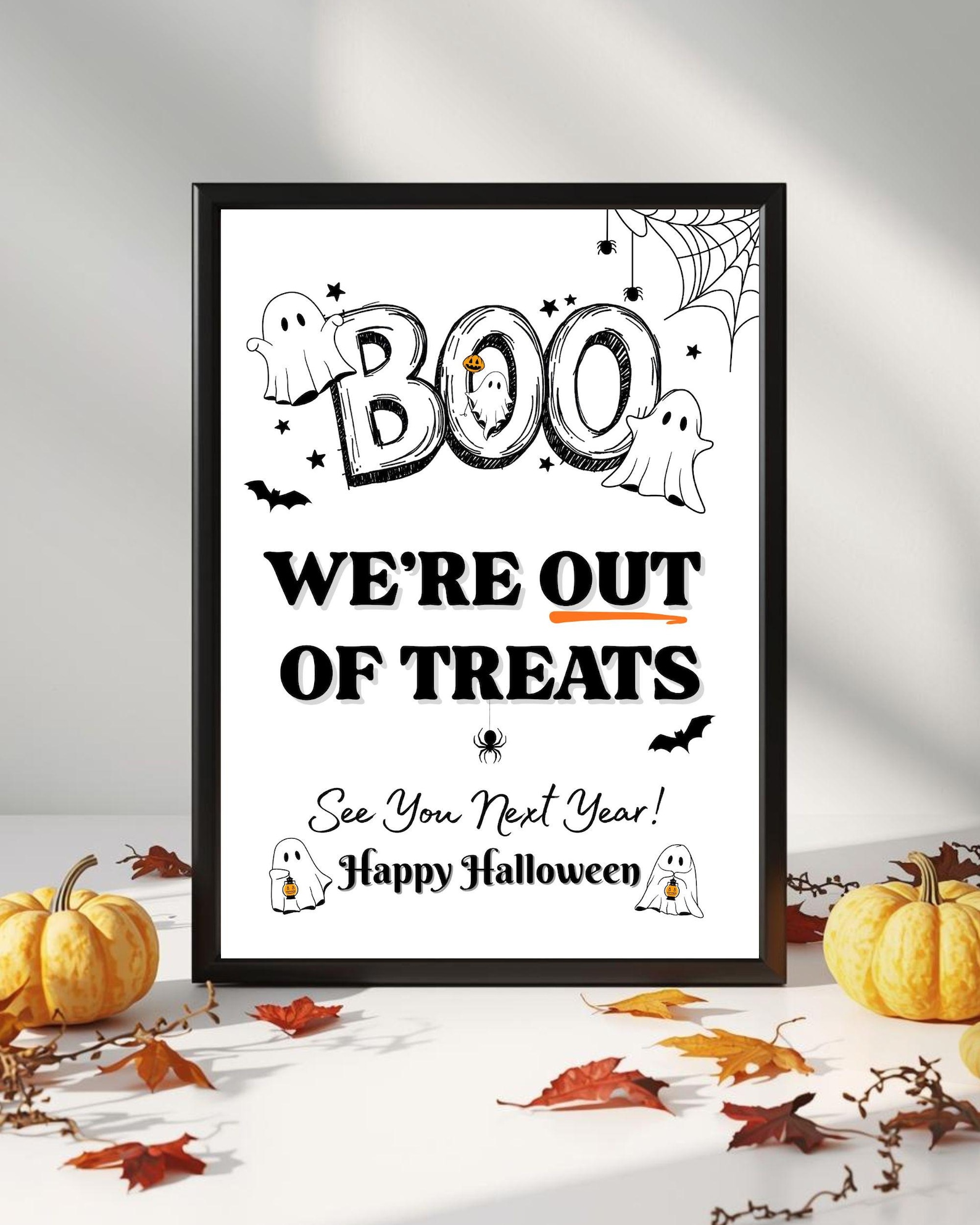A Big BOO Above an Empty-Bowl Notice Black-and-white BOO sign announcing that treats have run out.