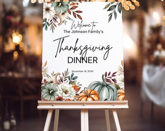 May include: Thanksgiving Dinner sign on a white easel. The sign features floral and pumpkin illustrations with the text "Welcome to The Johnson Family's Thanksgiving Dinner" and the date November 19, 20XX.