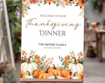 May include: Thanksgiving Dinner sign on a wooden easel. The sign features a floral border with orange and white pumpkins. Text reads "Welcome to our Thanksgiving Dinner" and includes the family name and date.