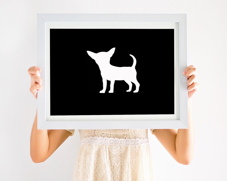 May include: A white silhouette of a chihuahua dog on a black background in a white frame.