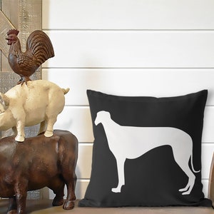 May include: Black and white throw pillow with a white silhouette of a greyhound dog on a black background.