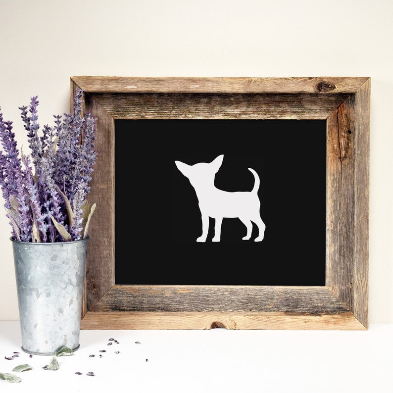 May include: A white silhouette of a chihuahua dog on a black background in a rustic wooden frame.