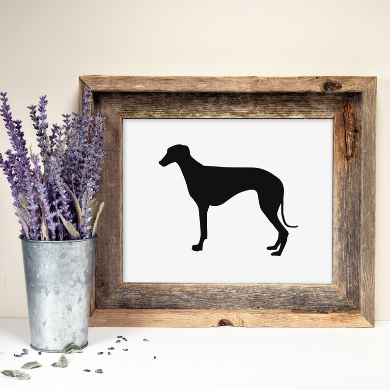May include: A black silhouette of a Greyhound dog printed on white paper and framed in a rustic brown wood frame.