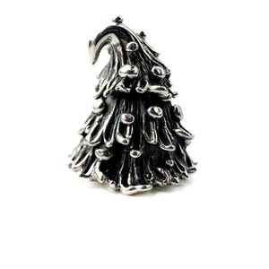 Può includere: Una statuetta a forma di albero di Natale argentato e stilizzato. L'albero ha un design strutturato e stratificato con piccoli ornamenti rotondi. La parte superiore dell'albero ha una forma curva e appuntita. La statuetta è su sfondo bianco.